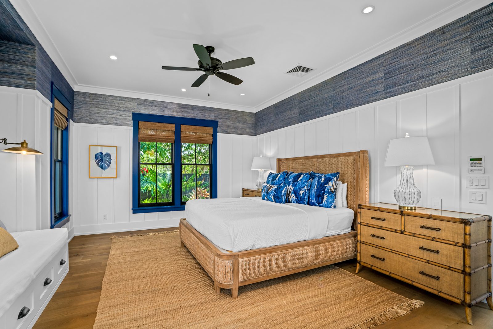 Blue Room with a woven rattan bed, indigo window trim and grasscloth walls
