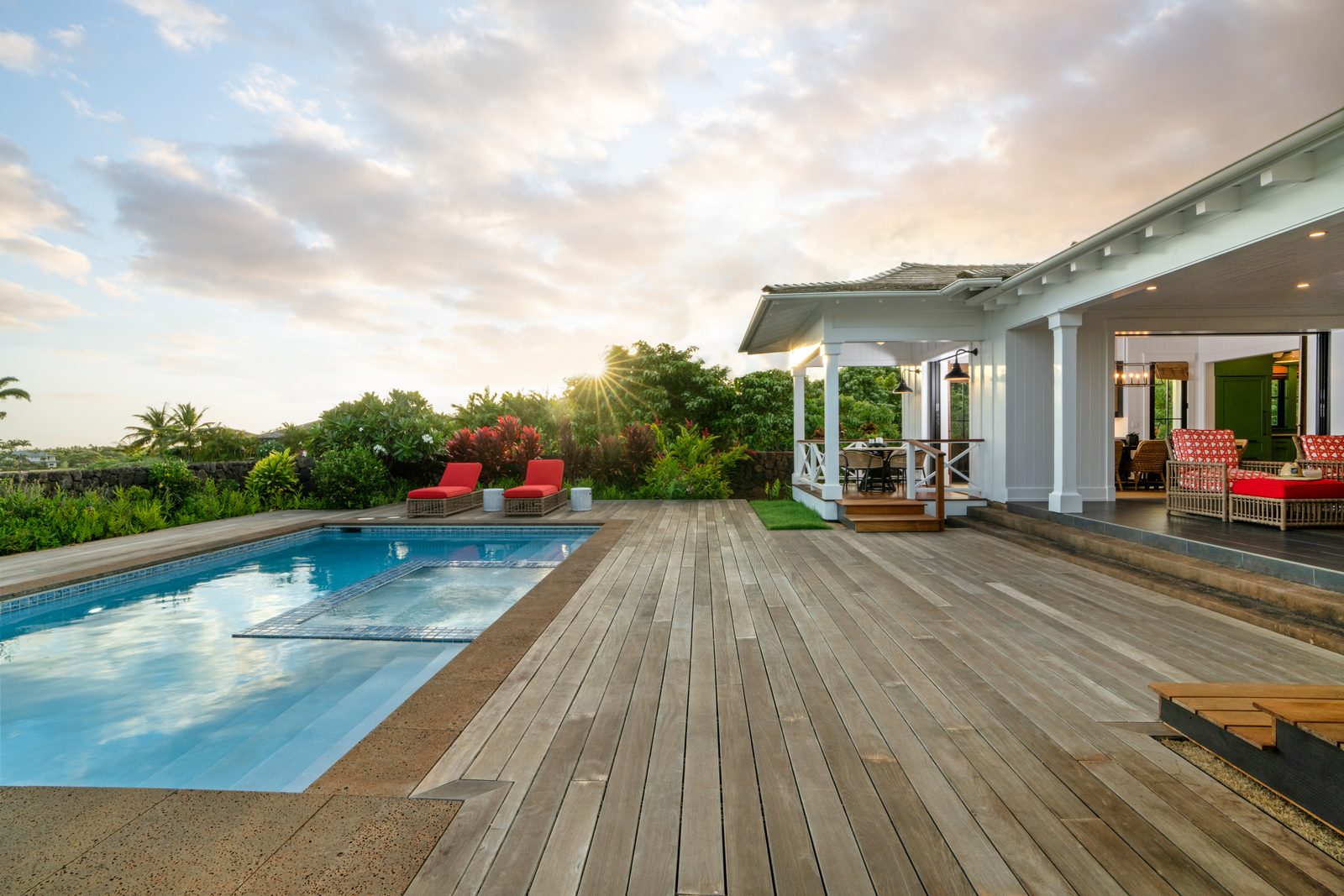 The wide teak pool deck with the lanai and house behind