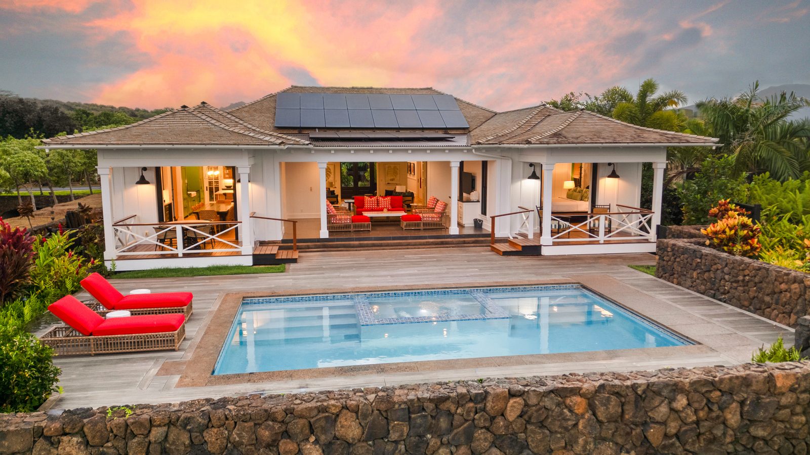 The house and pool at sunset under a flame-coloured sky